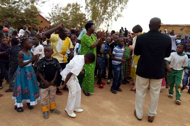 La responsable de l'APEE Rosalie Bassolé (en vert) danse avec les enfants