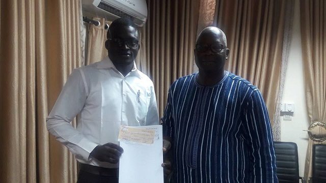 Remise du chèque par le ministre Sawadogo (à droite) à un représentant de parti politique