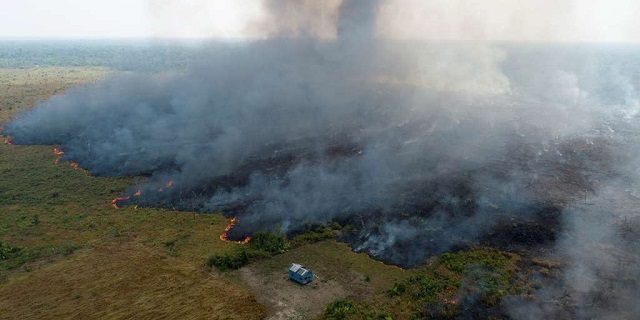 An aerial view shows smoke rising over a deforested plot of the Amazon jungle in Porto Velho