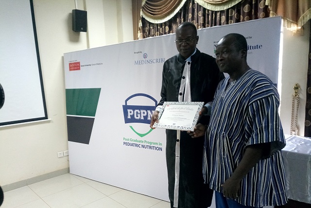 Dr Narcisse Naré, représentant du ministre de la Santé, remettant le diplôme d'un impétrant
