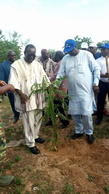 Le directeur général de la BDU (en casquette) et le maire de Loumbila plant un arbre