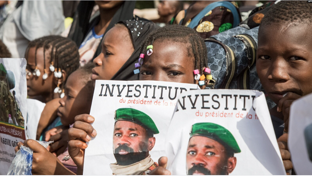 Des jeunes brandissant une affiche de Goita avant sa prestation de serment à Bamako le 7 juin 2021