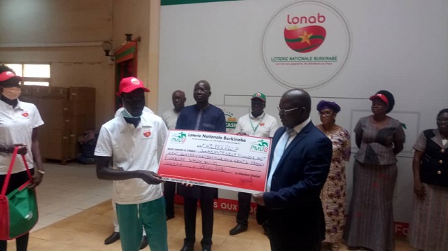 Le directeur général de la LONAB remettant le chèque au représentant du gagnant