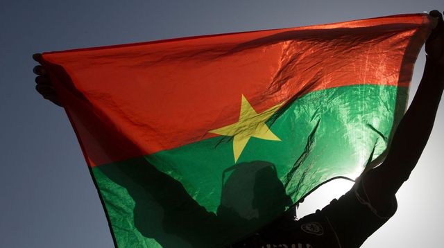 a-pro-democracy-protesters-holds-up-a-burkina-faso-flag-at-place-de-la-nation-in-ouagadougou_5159783