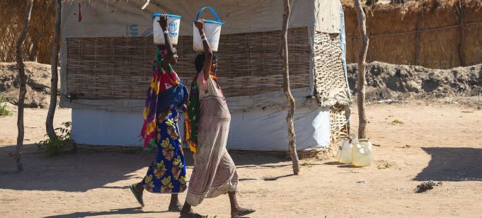 © UNICEF/Jospin Benekire Un bébé est tenu par sa mère devant leur maison à Kamanyola, dans la province du Sud-Kivu, en RD Congo.