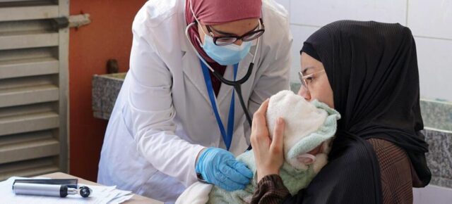 © Mousawat Une mère qui a été déplacée par le conflit au Liban fait examiner son enfant par un professionnel de la santé.