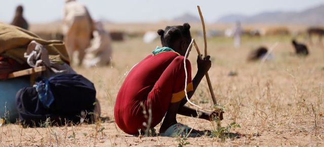 Une jeune fille creuse des trous pour créer un abri pour sa famille dans un camp de déplacés à Tawila où des centaines d'Al Fasher ont fui en sécurité