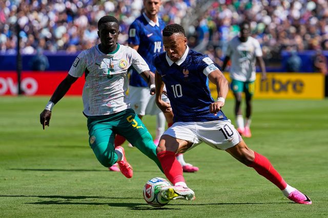 Kylian Mbappé portant le ballon devant le milieu défensif, Idrissa Gana Gueye