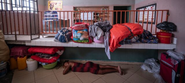 © OCHA/ Giles Clarke Une femme déplacée par la violence dort dans un magasin à Port-au-Prince.